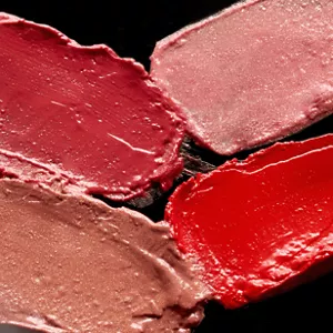Close up of four Lasting Plump Lipstick shade textures shown on black background